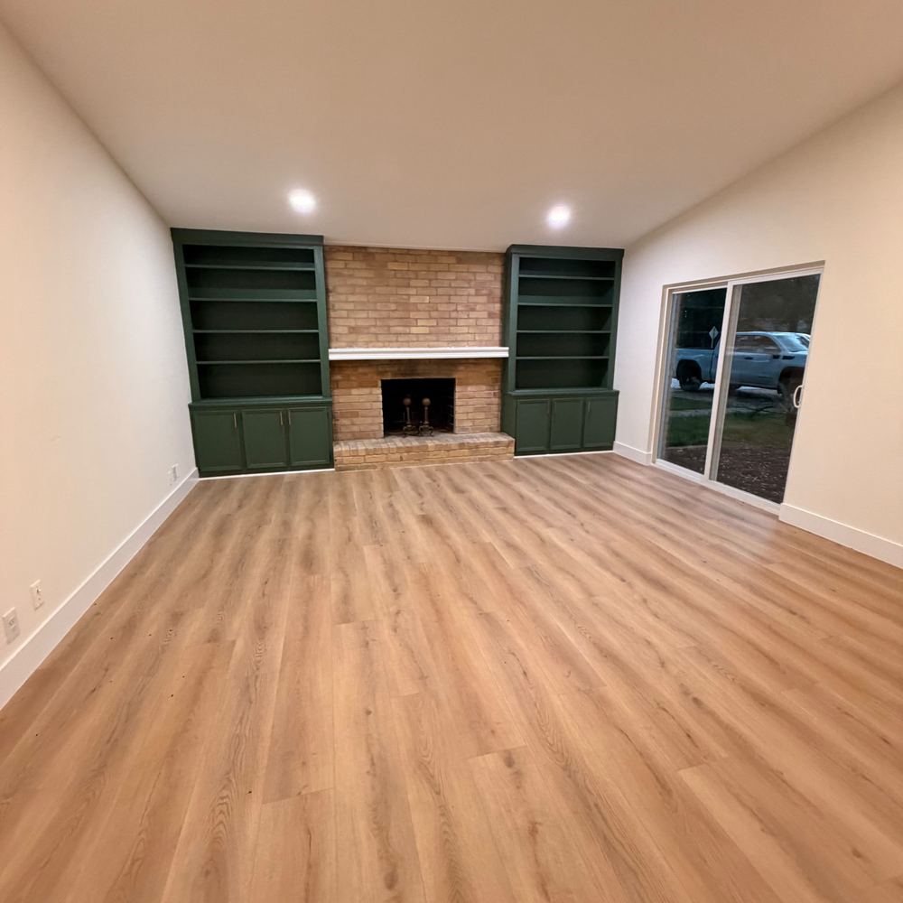 Sala con libreros verdes y chimenea de ladrillo
